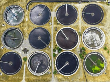 Kirli kanalizasyon suyunugeri dönüştürmek için yuvarlak havuzlu modern atıksu arıtma tesisi, drone'dan havadan görünüm