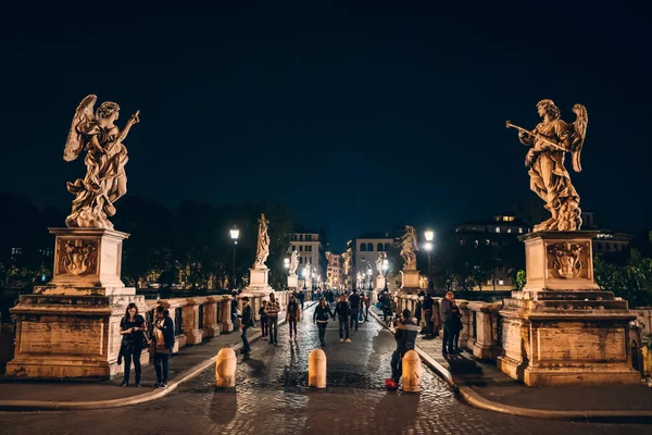 Roma, Italia - Octubre 2019: Puente al Castillo del Santo Ángel con estatuas y turistas de noche en el centro histórico de Roma — Foto de Stock