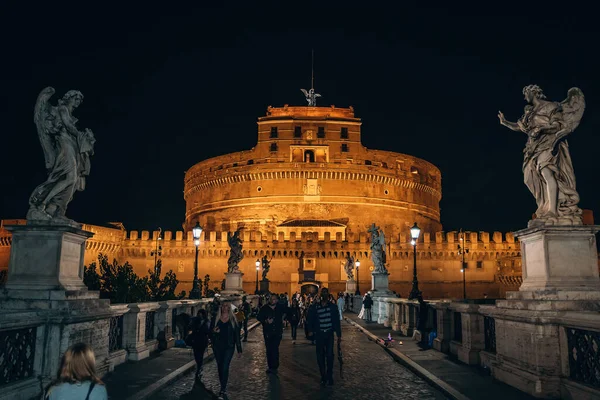 Roma, Itália - Outubro 2019: Ponte para o Castelo do Santo Anjo com estátuas e pessoas turistas à noite no centro histórico de Roma — Fotografia de Stock