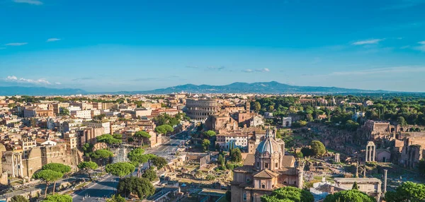 Panorama aéreo del Coliseo y Foro Romano en Roma, Italia. Hermoso paisaje urbano con antiguas ruinas famosas y el centro histórico de Roma, vista desde arriba — Foto de Stock