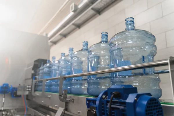 Línea transportadora de embotellado de agua con botellas de plástico o galones en la producción de la fábrica de agua, enfoque selectivo — Foto de Stock