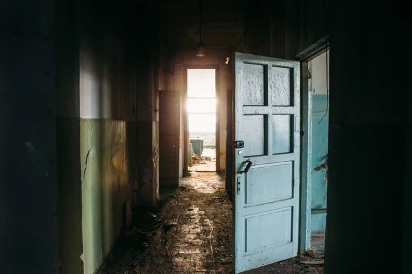 Corredor sujo em prédio abandonado, atmosfera assustadora com luz no final — Fotografia de Stock