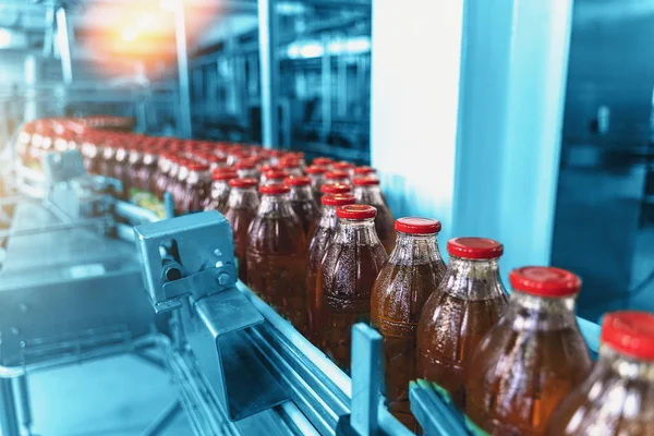 Conveyor belt, bottles in beverage plant or factory interior in blue color, industrial production line