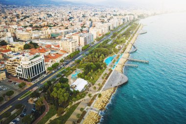 Limasol, Kıbrıs Rum Kesimi, gezinti güvertesi ya da toprak seti manzaralı. Tatil köyünde palmiyeleri ve ahşap iskeleleri olan ünlü Limasol yürüyüş yolu, insansız hava aracı fotoğrafı.