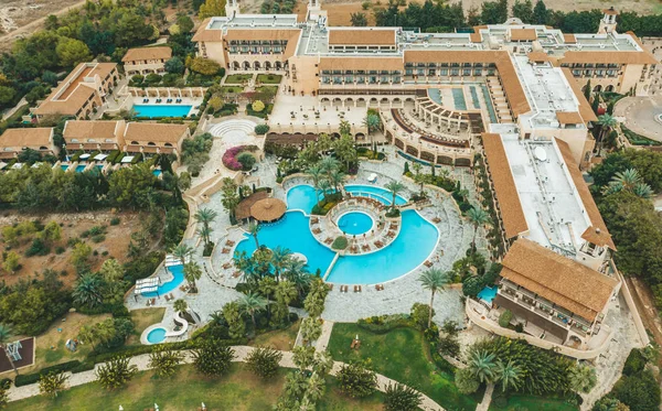 Aerial top view of little hotel with swimming pool, sunbeds and palms from above, tropical holiday resort, mediterranean paradise concept — Stock Photo, Image