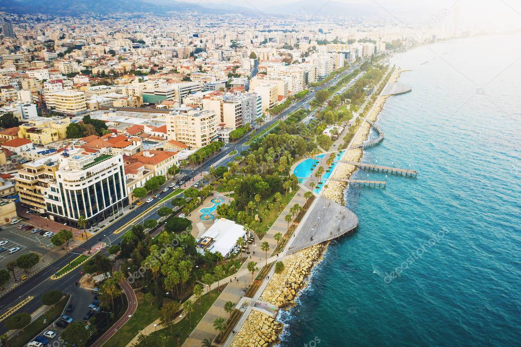 Limassol, Cyprus, aerial view at promenade or embankment. Famous Limassol walking alley with palms and wooden piers in resort town, drone photo