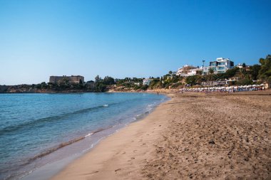 Paphos yakınlarındaki Kıbrıs 'taki Coral Bay kumlu plajı, popüler turizm beldesi
