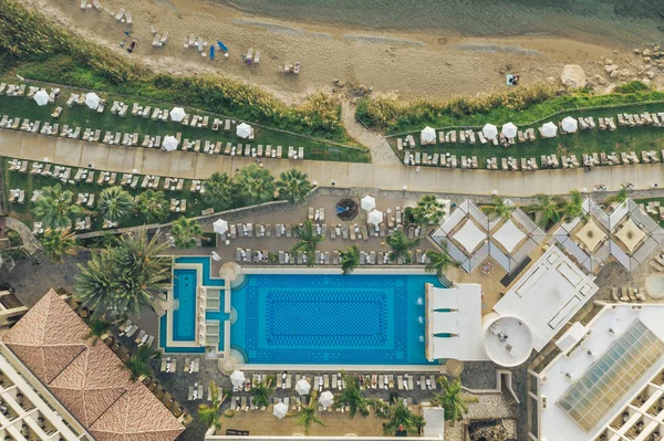 Aerial view of Cyprus hotel with pool, beach with people on sunbeds and umbrellas — Stock Photo, Image