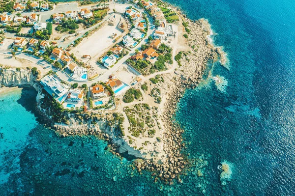 Aerial view of Cyprus island coast with villas for rent and rest and blue mediterranean sea, drone photo