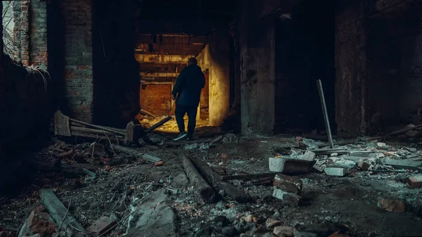 Hombre explorador con linterna en el interior del pasillo o túnel de la fábrica de construcción industrial en ruinas, horror y atmósfera espeluznante — Foto de Stock