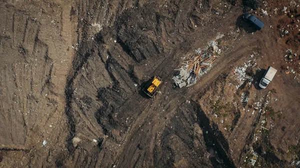 Aerial top view of a construction site or country dump with yellow excavator or bulldozer, heavy equipment, drone photo — Stock Photo, Image