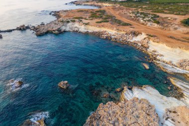 Kıbrıs Rum Kesimi doğa manzarası, mavi deniz suyu, seyahat ve macera konseptiyle kayalık kıyı şeridi manzarası