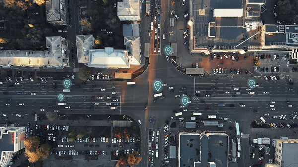 Aerial view of city intersection with many cars and GPS navigation system symbols. Autonomous driverless vehicles in city traffic. Future transportation concept.