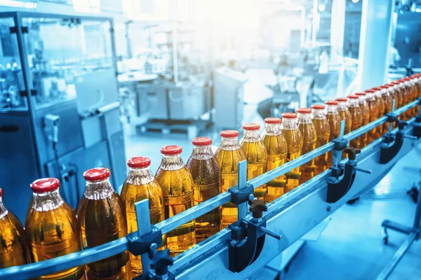 青の色で自然ジュース工場の生産の工業インテリア。コンベアベルト、飲料工場の充填ボトル、産業生産ライン — ストック写真