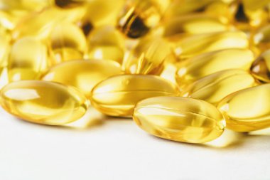 Omega 3 vitamini sarı takviye jel kapsülleri ya da beyaz arka planda balık yağı, morina yağı ilaçları, makro çekim.