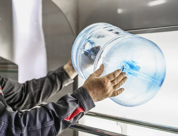Qualitätskontrolle in der Wasserproduktion Fabrik. Plastikflasche in den Händen des Arbeiters, Risskontrolle, Nahaufnahme — Stockfoto