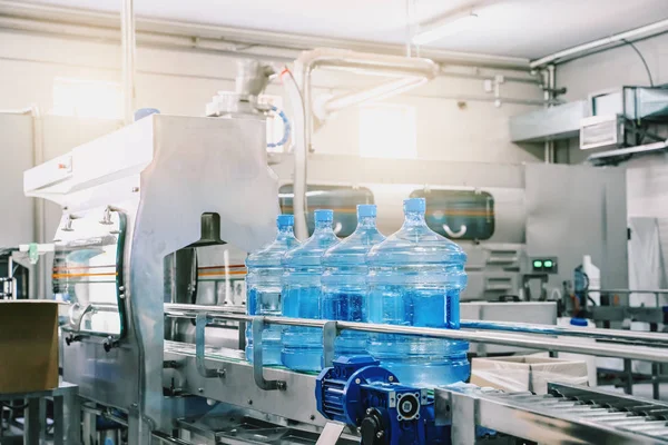 Industri interior produksi pabrik air. Sabuk pembawa, botol terisi pada pabrik minuman, lini produksi industri — Stok Foto