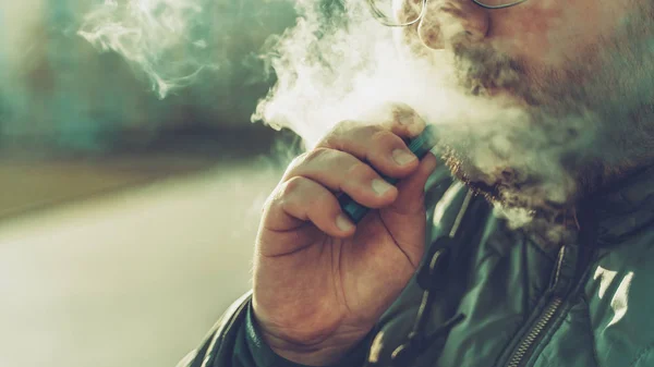 Az ember dohányzik az új Vape Pod System, kilégzi gőz elektronikus cigaretta, gőzölgő koncepció, szelektív fókusz, másolás tér — Stock Fotó