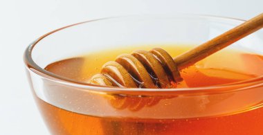 Beyaz arka planda bal küpü ve dipper, makro fotoğraf