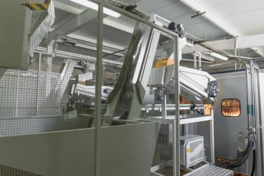 Hayvan preformlarından plastik şişe üfleme makinesi, fabrikanın iç kısımlarında endüstriyel taşıyıcı bant
