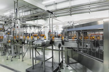Doğal meyve suyu üretiminin endüstriyel iç mekanı. Taşıma bandı, içecek fabrikasındaki şişeler, endüstriyel üretim hattı.