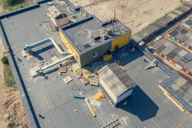 İnşaat alanında çalışan işçilerle çatı, hava manzarası.