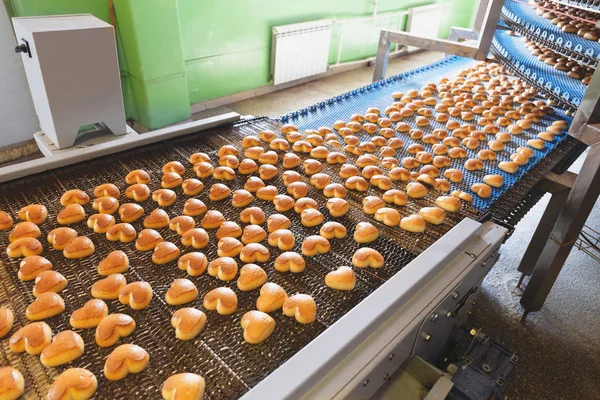 Pastry on conveyor line, food production factory, close up Royalty Free Stock Photos