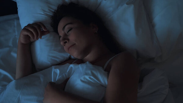 Young woman sleeps in bed top view, close up, resting and relax concept
