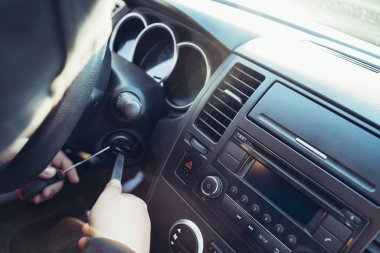 Suçlu, araba çalmak için kontağı kırıyor, kapat. Araba hırsızlığı konsepti