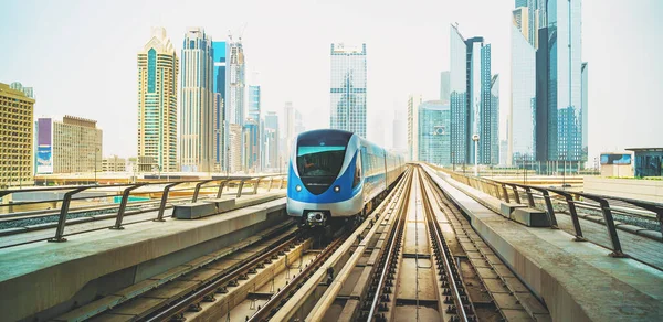 Metro trem na linha vermelha no centro de Dubai com arranha-céus no fundo — Fotografia de Stock