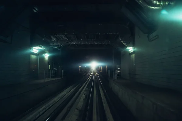 Dubai tunnelbana tunnel i suddig rörelse med ljus i slutet, vy från första vagnen, tunnelbana spår — Stockfoto
