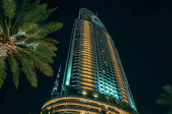 Ypical Dubai skyscraper building and palm at night sky background, holiday in UAE Dubai concept — Stock Photo, Image