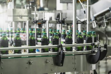 İçecek fabrikası üretiminin endüstriyel iç mekanı. Taşıyıcı bant, fabrikada plastik şişeler, endüstriyel üretim hattı