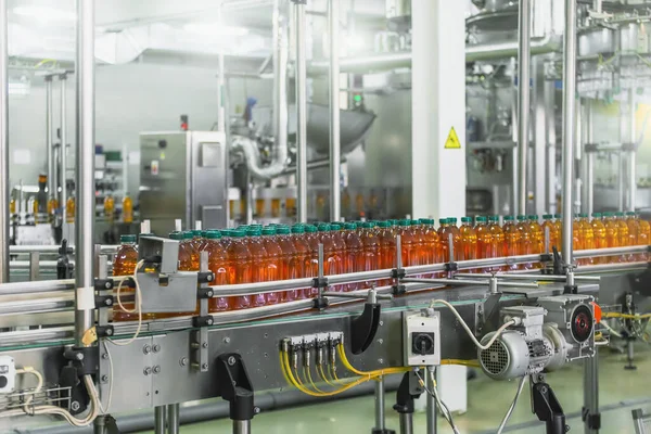 Förderband, Saft in Flaschen auf Getränkeanlagen oder Fabrikinnenräumen, industrielle Produktionslinie — Stockfoto