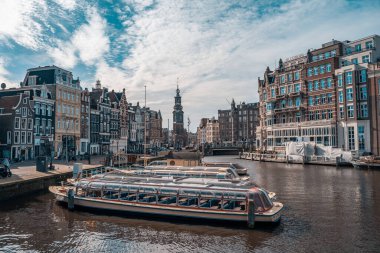 Amsterdam, Hollanda - 18 Mart 2020: Kanalları ve dar binaları olan tipik Amsterdam manzarası. İnsansız sokaklar, kapalı dükkanlar ve restoranlar, karantina, Coronavirus salgını