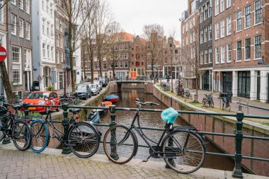 Amsterdam, Hollanda - 18 Mart 2020: Kanalları ve dar binaları olan tipik Amsterdam manzarası. İnsansız sokaklar, kapalı dükkanlar ve restoranlar, karantina, Coronavirus salgını