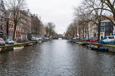Amsterdam, Hollanda - 18 Mart 2020: Kanalları ve dar binaları olan tipik Amsterdam manzarası. İnsansız sokaklar, kapalı dükkanlar ve restoranlar, karantina, Coronavirus salgını