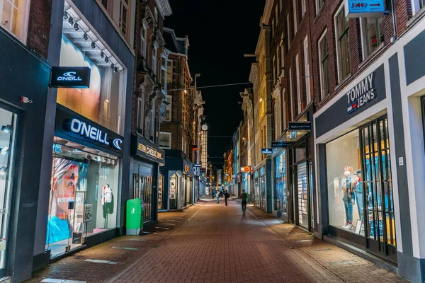 Amsterdam, Niederlande - 18. März 2020: Leere Einkaufsstraße mit geschlossenen Geschäften am Abend in der touristischen Innenstadt von Amsterdam, Stadt unter Quarantäne wegen Coronavirus — Stockfoto