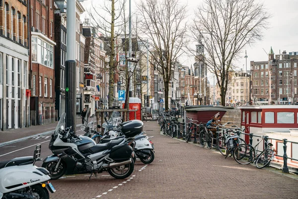 Amsterdam, 18 maart 2020: Halve lege straten van het historische centrum van Amsterdam, weinig mensen en toeristen op straat, stad in quarantaine door uitbraak van het Coronavirus — Stockfoto