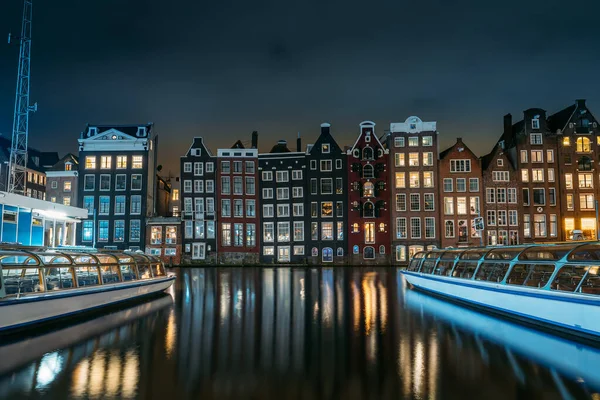 Canal d'Amsterdam Singel avec maisons de danse et péniches la nuit avec réflexion de l'éclairage dans l'eau, Pays-Bas — Photo