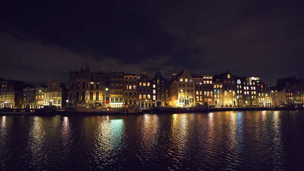 Kanal von Amsterdam bei Nacht mit Reflexion beleuchteter Häuser im Wasser, Niederlande. Schöne alte europäische Stadtansichten — Stockfoto