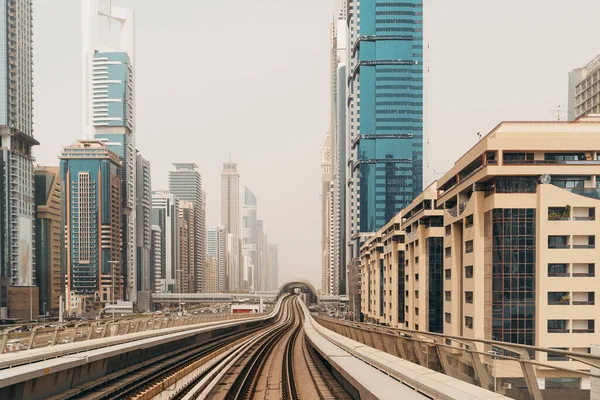 Dubai metro railroad at new futuristic skyscrapers buildings skyline background — Stock Photo, Image
