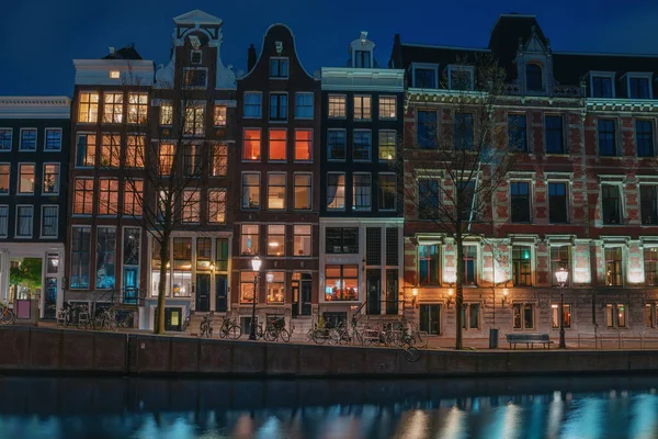 Antiguas casas de baile tradicionales o edificios en Amsterdam por la noche, los Países Bajos — Foto de Stock