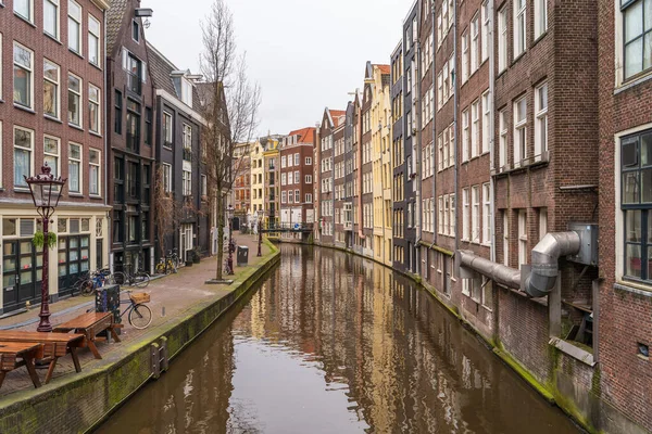 Typisch beroemde watergrachten en dansende huizen in leeg Amsterdam centrum zonder mensen door het Coronavirus Covid-19, Nederland — Stockfoto