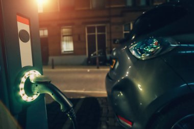 Hollanda 'nın gece caddesindeki kamu şarj istasyonunda elektrikli araba şarj ediliyor.