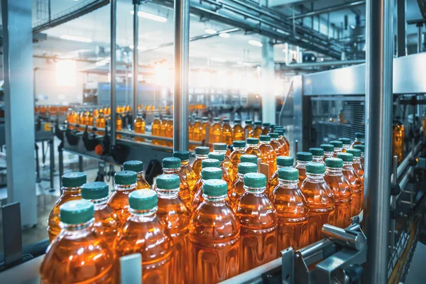 Cinta transportadora, jugo en botellas, interior de la fábrica de bebidas en color azul, línea de producción industrial —  Fotos de Stock