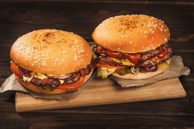 İki büyük ev yapımı hamburger ya da büyük kavrulmuş etli hamburger, yakın çekim.