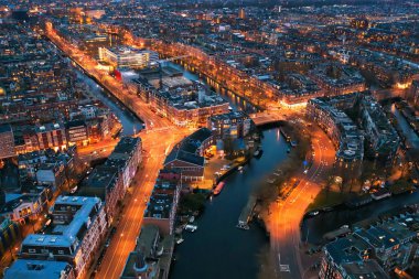 Amsterdam şehir merkezinin panoramik hava manzarası. Akşam Hollanda 'da kanallar, sokaklar ve binalar var.