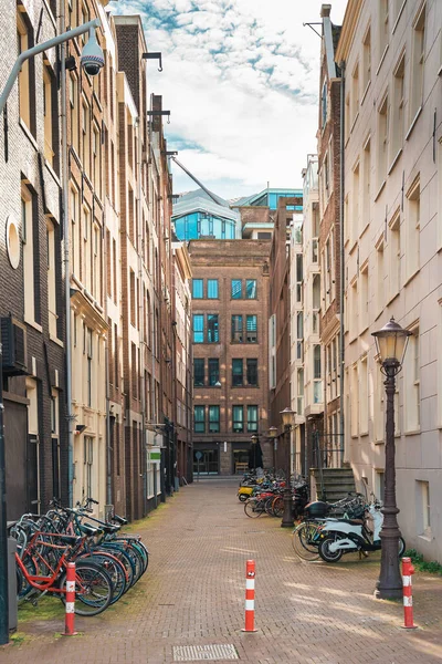 Typische enge Straße in Amsterdam mit tanzenden Häusern und Fahrrädern, Niederlande — Stockfoto