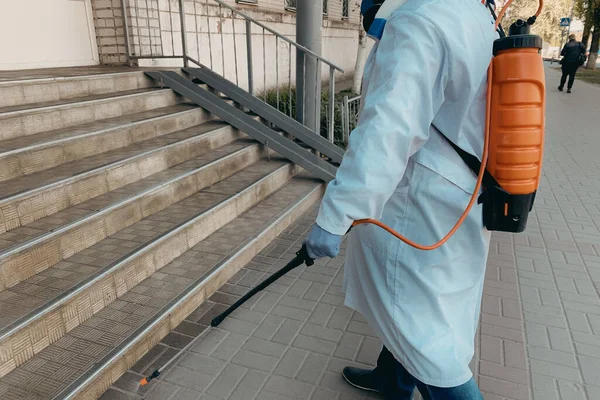 Disinfecting by spray from Corona virus of residential building entrance by worker in special uniform, epidemic prevention COVID-19 — Stock Photo, Image